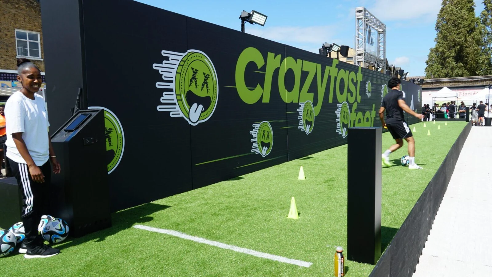 Football challenge lane with artificial turf and black-and-green Adidas Crazyfast graphics.