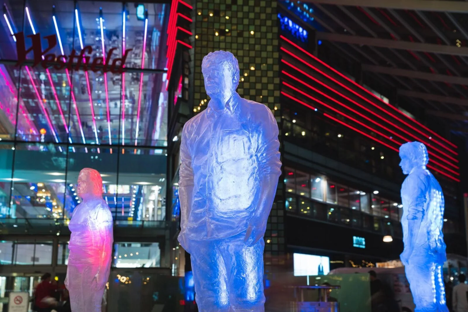 Blue and pink illuminated figures outside a shopping centre for Make Blood Cancer Visible.