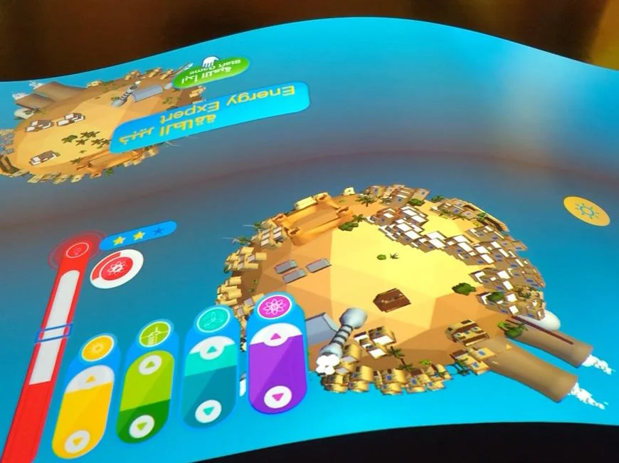 Projected island landscape and coloured energy meters on the Energy Manager table.