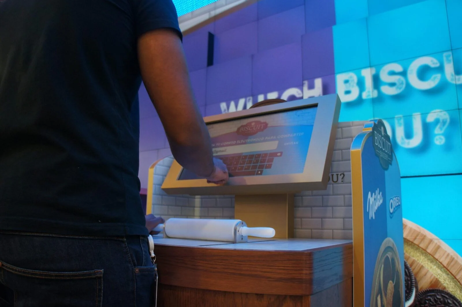 Close-up of a visitor using the Mondelez kiosk, with a rolling pin beneath its touchscreen.