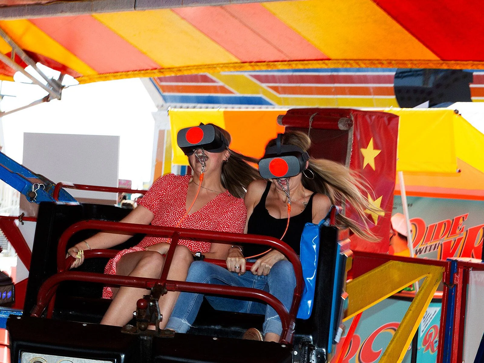 Two riders wearing virtual reality headsets on the Twister ride at Brighton Pier.